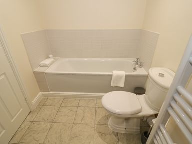A bathroom with a bathtub and a toilet at The Wheat House in Welford-On-Avon