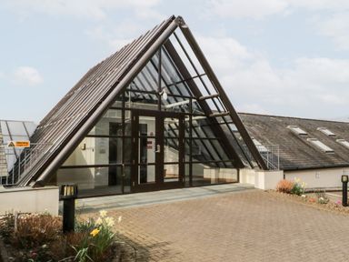 An entrance with glass double doors and a triangular glass roof over the doorway at Rothay in Ambleside