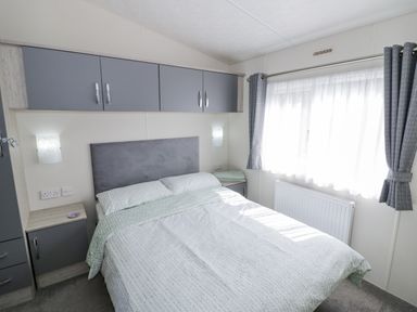 A bedroom with a bed and bedside table at Serendipity