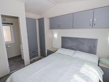 A bedroom with a bed and storage units at Serendipity