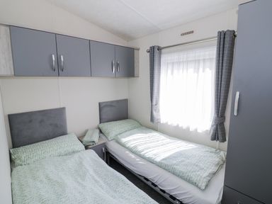 A bedroom with two beds and a window at Serendipity