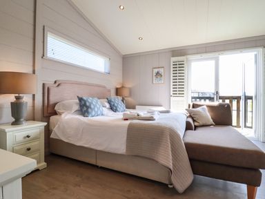 A bedroom with a large bed pillows and lamps on bedside tables at Skylarks in Fornham St Genevieve near Bury St Edmunds