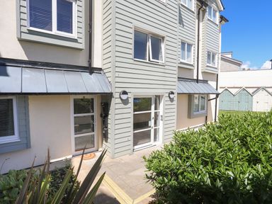 Exterior view of a residential building with windows doors metal awnings and bushes in front at 4 Pen Llanw Tides Reach in Rhosneigr