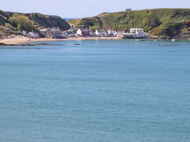 A coastal village with houses near the beach and hills overlooking the water at Bryn Moelyn Cottage in Yr Efail near Morfa Nefyn