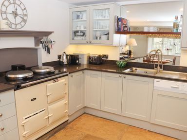 A kitchen with an aga stove kettle toaster and sink at Manor Cottage in Poulton