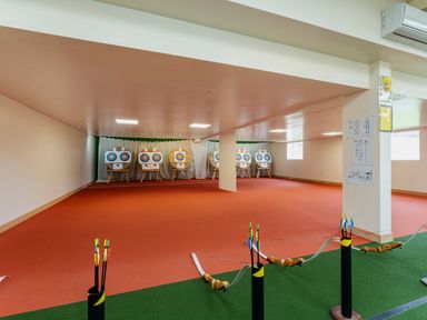 An indoor archery range with bows arrows and targets at Ridge's Retreat No 7 Kigbeare Lodges in Ashbury Resort near Fowley Cross Sourton Down and Okehampton