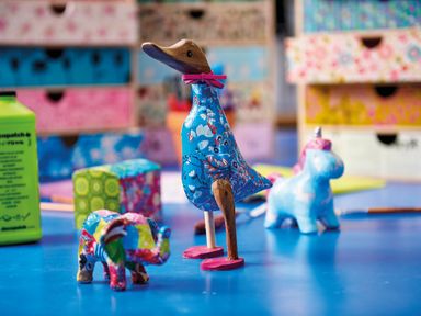 A blue table with colorful handmade animal figurines and patterned storage boxes in the background at Ridges Retreat No 7 Kigbeare Lodges Ashbury Resort near Fowley Cross Sourton Down and Okehampton