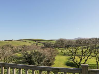 A wooden railing overlooking a green landscape with trees and hills at Ridge's Retreat No 7 Kigbeare Lodges Ashbury Resort near Fowley Cross Sourton Down and Okehampton