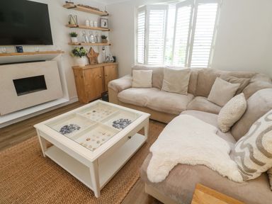 A living room with a sofa and a coffee table at Trelowen in St Issey near Padstow