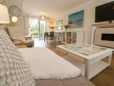 A living room with a coffee table and dining area at Trelowen St Issey near Padstow