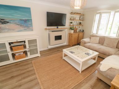 A living room with a sofa and a coffee table at Trelowen in St Issey near Padstow