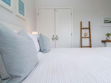 A bedroom with a bed and wardrobe at Trelowen St Issey near Padstow