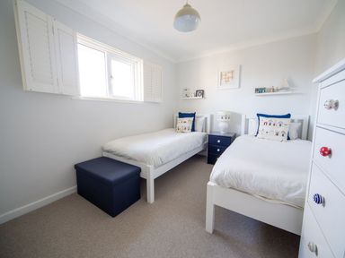 A bedroom with two single beds and a bedside table at Trelowen in St Issey near Padstow
