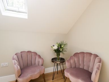 A corner with two pink velvet chairs and a round side table with flowers at Little Lugg in Cross Keys near Hereford