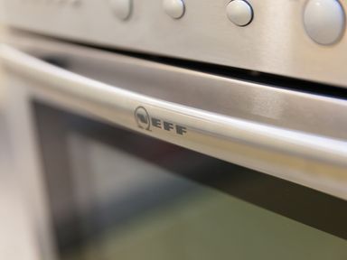 A close up of a stainless steel Neff oven door and control knobs