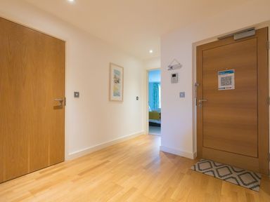 A hallway with wooden doors and a framed picture on the wall at Golden Sands in Carbis Bay