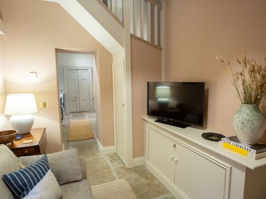 A living room with a sofa and TV on a cabinet at The Tower in Kirklinton near Longtown
