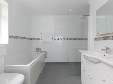 A bathroom with a bathtub shower toilet and sink at Moonbeams in Carbis Bay