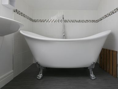 A bathroom with a clawfoot bathtub and a pedestal sink at Moonbeams in Carbis Bay