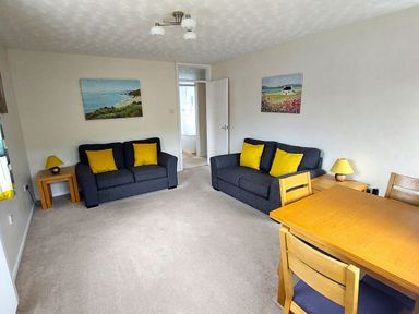 A living room with sofas and a table at West Lulworth Apartment in West Lulworth