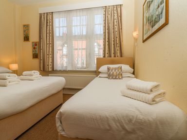 A bedroom with two single beds and folded towels on them at Lonsdale Villa Scarborough