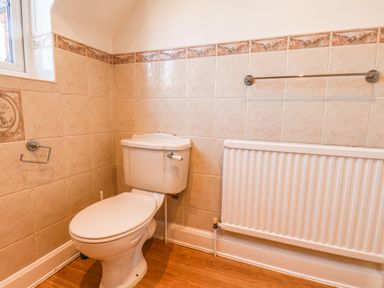 A bathroom with a toilet radiator and towel rail at Lonsdale Villa in Scarborough