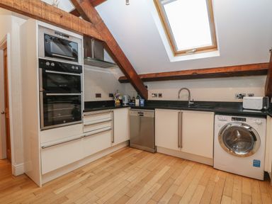 A kitchen with built-in ovens dishwasher washing machine and a skylight window at Apartment 2 Gorwel Glas in Llanbedrog