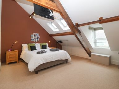 A bedroom with a double bed bedside tables and skylights at Apartment 2 Gorwel Glas in Llanbedrog