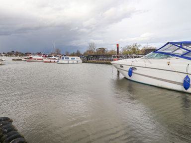 A marina with several boats docked in the water at Marsh Bungalow in Lowestoft