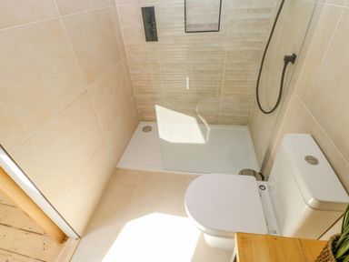 A bathroom with a toilet and a walk-in shower with glass screen at Bramwell House in Corbridge