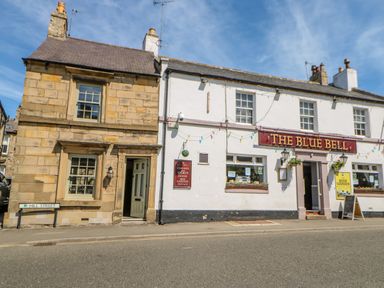 A street view of The Blue Bell pub and an adjacent stone building on Hill Street