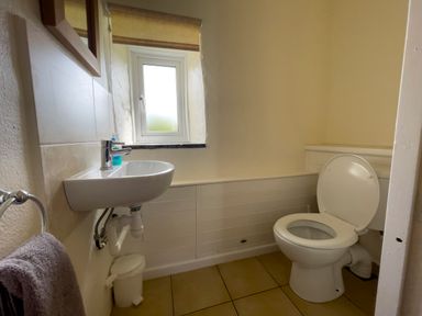 A bathroom with a toilet sink window and towel at The Granary @ Canllefaes in Penparc near Cardigan