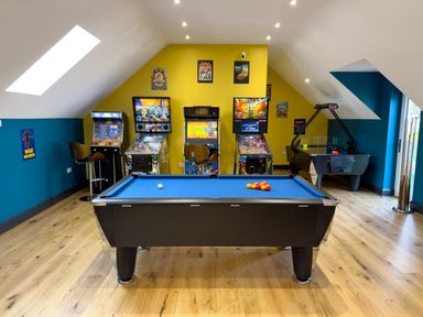 A game room with a pool table a pinball machines an arcade game stools and an air hockey table at The Granary @ Canllefaes in Penparc near Cardigan