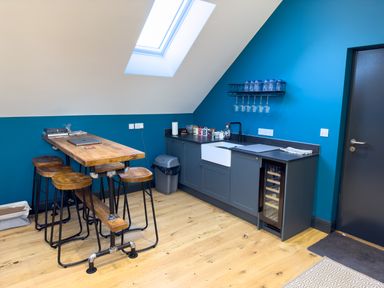 A kitchen area with a wooden table and stools under a skylight at The Granary @ Canllefaes in Penparc near Cardigan