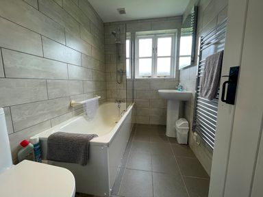 A bathroom with a bathtub shower sink toilet and towel racks at The Wheel @ Canllefaes in Penparc near Cardigan
