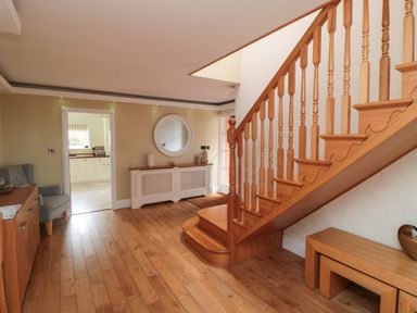 A hallway with a staircase and a console table at Wyvill House in Cayton