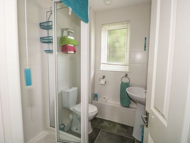 A bathroom with a shower enclosure toilet sink and window at Hillside in Gunnislake