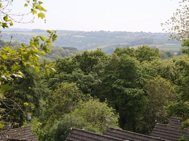 A landscape view of trees and hills seen from rooftops at Hillside in Gunnislake