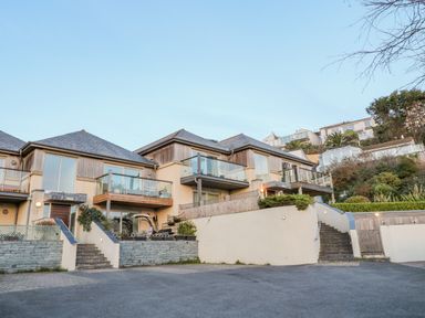 A view of modern houses with balconies and stairs on a hillside at A Stone's Throw in Downderry