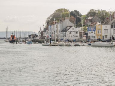 A harbor with boats and sailboats docked near buildings at Fisherman's Rest in Wyke Regis