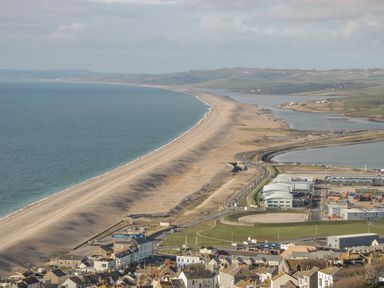 A coastal town with a long narrow beach extending into the distance at Fisherman's Rest in Wyke Regis