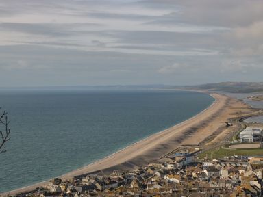 A coastal town with houses near a long curved sandy beach and sea at Fisherman's Rest in Wyke Regis