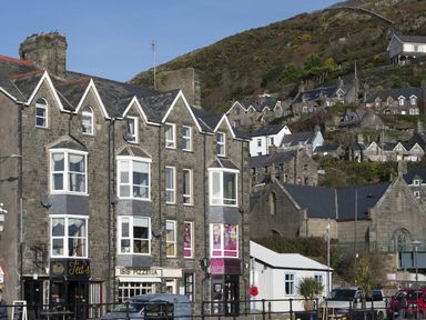 Stone buildings with shops and houses on a hillside in Barmouth