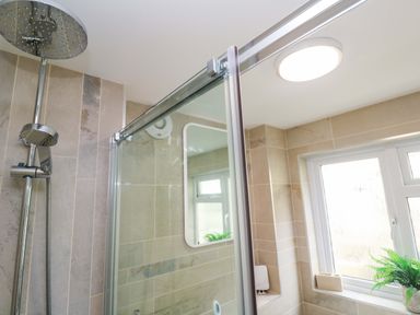 A bathroom with a shower and a window at Driftwood in Marazion
