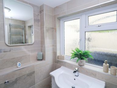 A bathroom with a sink and towel rail at Driftwood in Marazion