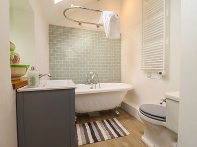 A bathroom with a clawfoot bathtub a sink with a soap dispenser a toilet and a towel radiator at The Nook in Jacks Green near Painswick