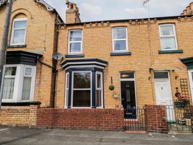 A brick terraced house with a black front door and bay window at 89 Caledonia Street in Scarborough