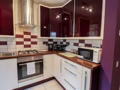 A kitchen with a gas stove oven microwave kettle toaster and dark and light cabinets at 89 Caledonia Street Scarborough