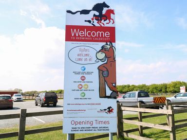 A parking lot with cars and a welcome sign for Redwings Caldecott horse sanctuary at Audrey's Lodge Foxburrow Hang in Fritton