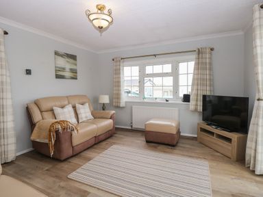 A living room with a sofa and television at Seaward in Trimingham